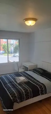 a bedroom with a large bed and a window at Confort in Montréal
