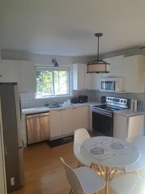 a kitchen with a table and a table and chairs at Confort in Montréal