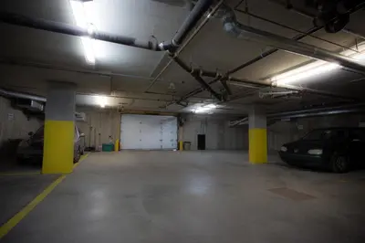a parking garage with two cars parked in it at ApartHotelMontreal by Les Terrasses Saint Urbain 2225I2 in Montréal