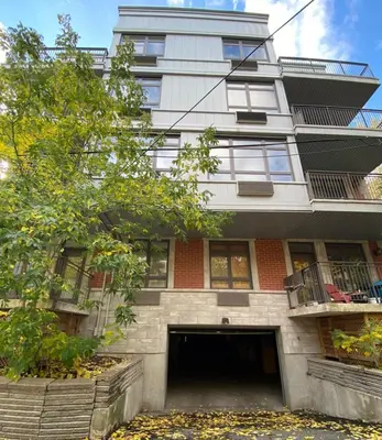 an apartment building with a parking garage in front of it at ApartHotelMontreal by Les Terrasses Saint Urbain 2225I2 in Montréal