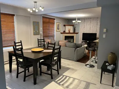 a dining room and living room with a table and chairs at ApartHotelMontreal by Les Terrasses Saint Urbain 2225I2 in Montréal