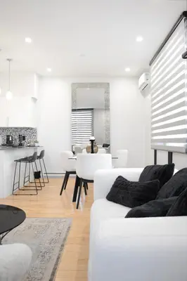 a white living room with a white couch and a table at Chic 1-Bedroom Retreat in Montreal's Vibrant Plateau Mont-Royal Area - Apt 3 in Montréal
