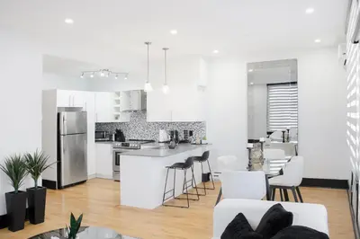 an open kitchen and living room with white appliances at Chic 1-Bedroom Retreat in Montreal's Vibrant Plateau Mont-Royal Area - Apt 3 in Montréal
