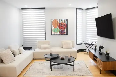 a living room with a white couch and a tv at Eat, Explore & Enjoy Downtown Montreal at this Sleek City Escape located in Plateau Mont-Royal - Apt 4 in Montréal