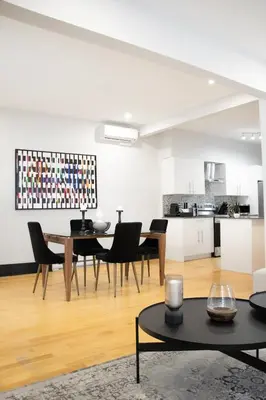 a living room with a table and chairs and a kitchen at Eat, Explore & Enjoy Downtown Montreal at this Sleek City Escape located in Plateau Mont-Royal - Apt 4 in Montréal