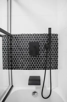 a bathroom with a black and white tiled wall at Eat, Explore & Enjoy Downtown Montreal at this Sleek City Escape located in Plateau Mont-Royal - Apt 4 in Montréal