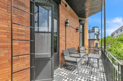 a balcony with chairs on a brick building at Upscale 3-Bedroom Entire Unit in the Trendy Plateau Mont-Royal featuring A Magazine-Worthy Kitchen & Opulent Living Spaces - Apt 1 in Montréal