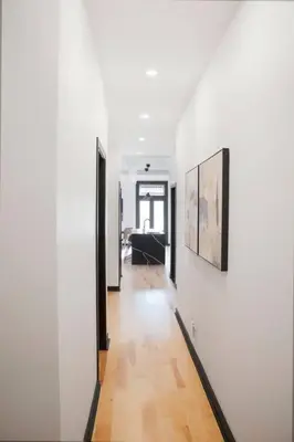 a hallway of a house with white walls and wooden floors at Upscale 3-Bedroom Entire Unit in the Trendy Plateau Mont-Royal featuring A Magazine-Worthy Kitchen & Opulent Living Spaces - Apt 1 in Montréal