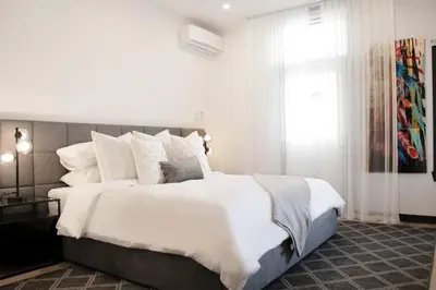 a bedroom with a large bed with white sheets and pillows at Upscale 3-Bedroom Entire Unit in the Trendy Plateau Mont-Royal featuring A Magazine-Worthy Kitchen & Opulent Living Spaces - Apt 1 in Montréal