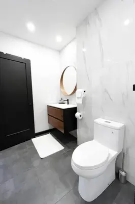 a bathroom with a white toilet and a sink at Upscale 3-Bedroom Entire Unit in the Trendy Plateau Mont-Royal featuring A Magazine-Worthy Kitchen & Opulent Living Spaces - Apt 1 in Montréal
