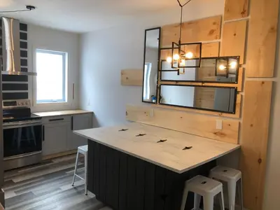 a kitchen with a large island with two stools at Domaine des Montagnais in Notre-Dame-Des-Bois