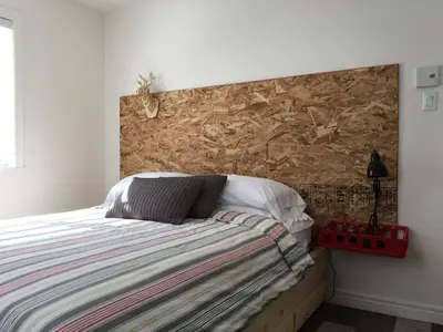 a bedroom with a bed with a wooden headboard at Domaine des Montagnais in Notre-Dame-Des-Bois