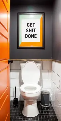 a bathroom with a toilet and a picture on the wall at Le Bed & Cocktail - Appartement sur l'Avenue du Mont-Royal in Montréal