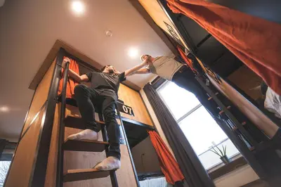 two people on a ladder in a bunk bed at Le Bed & Cocktail - Appartement sur l'Avenue du Mont-Royal in Montréal