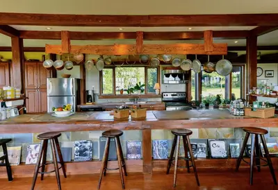 a kitchen with a large wooden bar with stools at Sugar Hill Retreat #296692 in Lac-Brome