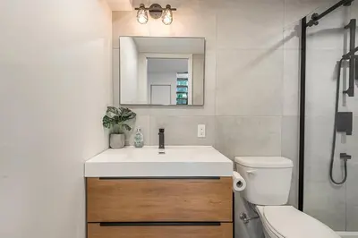 a bathroom with a sink and a toilet and a mirror at FREE PARKING PRIME LOCATION NEW MODERN CONDO in Brossard