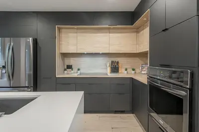 a kitchen with black cabinets and stainless steel appliances at FREE PARKING PRIME LOCATION NEW MODERN CONDO in Brossard