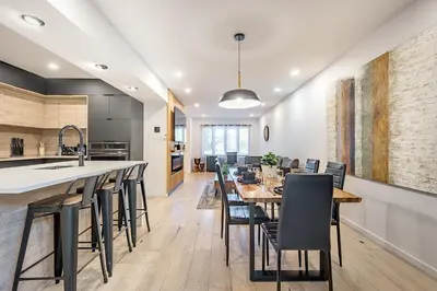 a kitchen and dining room with a long table and chairs at FREE PARKING PRIME LOCATION NEW MODERN CONDO in Brossard