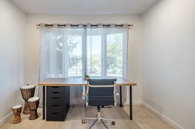 a desk with a chair in front of a window at FREE PARKING PRIME LOCATION NEW MODERN CONDO in Brossard