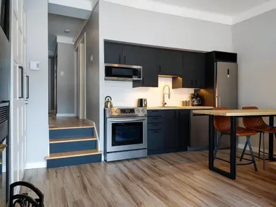 a kitchen with black cabinets and a table and a counter at Chalet Détente Orford in Orford