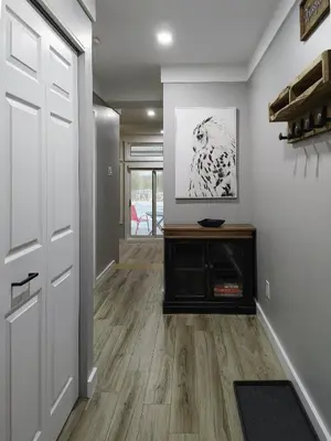 a hallway of a home with a door and wood floors at Chalet Détente Orford in Orford