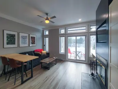 a living room with a table and a couch at Chalet Détente Orford in Orford