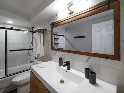 a bathroom with a sink and a toilet and a mirror at Chalet Détente Orford in Orford