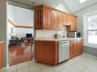 a kitchen with wooden cabinets and a dining room at Chalet Évasion Orford in Orford