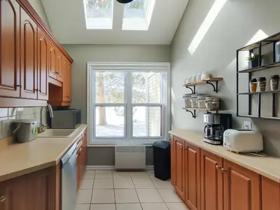 a kitchen with a sink and a window at Chalet Évasion Orford in Orford