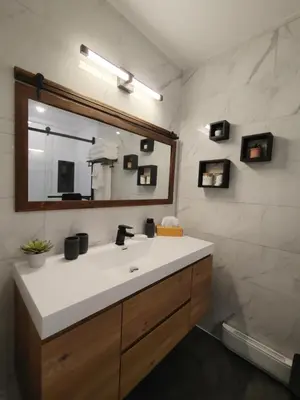 a bathroom with a sink and a mirror and a tub at Chalet Évasion Orford in Orford