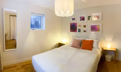 a bedroom with a large white bed with two lamps at Le Camp Caché Shefford in Shefford