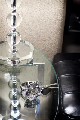 a glass table with a glass candle holder on it at Le Pleasant Hôtel & Café in Sutton