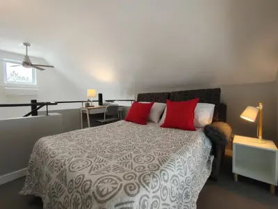 a bedroom with a large bed with red pillows at Chalet Escapade Orford in Orford