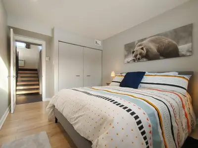 a bedroom with a bed with a rat on the wall at Chalet Escapade Orford in Orford