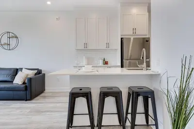 a kitchen with a counter and two stools in a kitchen at Le Mile End by M11 - Neat & Spacious 1BDR Unit in Montréal