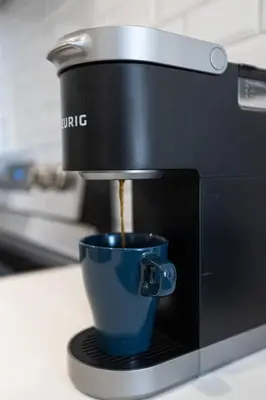 a coffee maker is making a cup of coffee at Le Mile End by M11 - Neat & Spacious 1BDR Unit in Montréal
