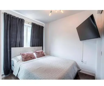 a bedroom with a bed with two pillows on it at 2 bedroom Condo in the heart of the city Montreal in Montréal