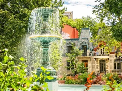 a fountain in the middle of a yard with a house at 2 bedroom Condo in the heart of the city Montreal in Montréal