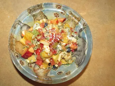 a glass bowl filled with a salad on a table at Le Gîte Ambrelane in Thetford Mines