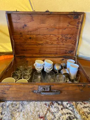 a wooden chest filled with glasses and dishes at Glamping 4 saisons @ Eco Lodge Bûcheron Bergère in Ormstown