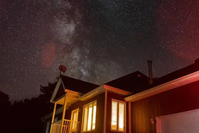 a house with the milky way in the sky at Chalet in a dark sky reserve in Notre-Dame-Des-Bois