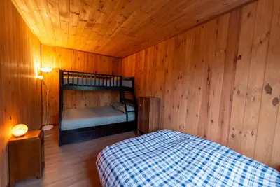 a bedroom with a bed in a wooden room at Chalet in a dark sky reserve in Notre-Dame-Des-Bois