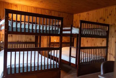 two bunk beds in a room with wooden walls at Chalet in a dark sky reserve in Notre-Dame-Des-Bois