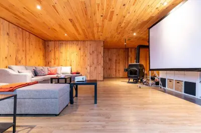 a living room with a couch and a projection screen at Chalet in a dark sky reserve in Notre-Dame-Des-Bois