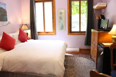 a bedroom with a white bed with red pillows at La Loggia Art B&B in Montréal