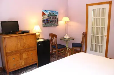 a bedroom with a bed and a dresser with a television at La Loggia Art B&B in Montréal