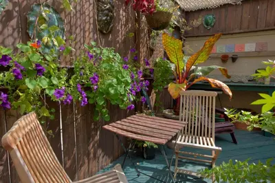 a wooden table and two chairs on a patio with flowers at La Loggia Art B&B in Montréal