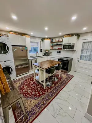 a large kitchen with a wooden table and a stove at Barel Residence Homestay in Longueuil