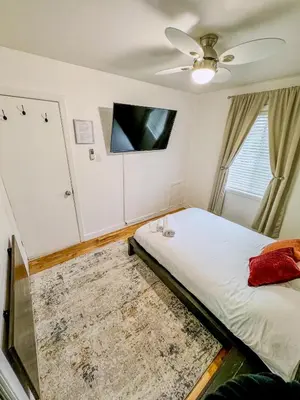 a bedroom with a bed and a tv on the wall at Barel Residence Homestay in Longueuil