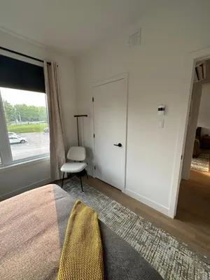 a bedroom with a bed and a window and a chair at Le Joford in Orford